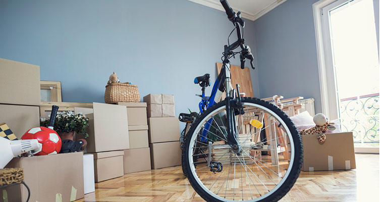 Habitación con cajas empaquetadas y una bicicleta, ejemplo de organización creativa en un trastero