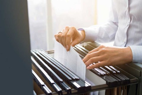 Close-up of businessperson filing documents in a cabinet, representing secure archive storage with OhMyBox.