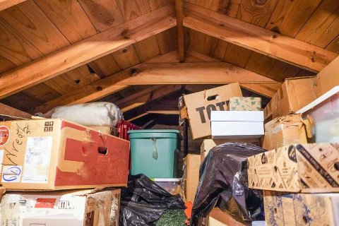 Cluttered attic full of boxes and decorations, showing items that can be safely stored with OhMyBox.